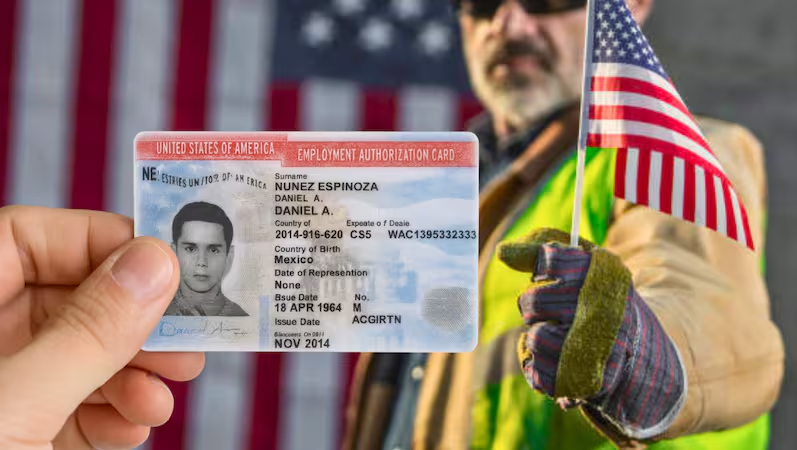 A hand holds an employment authorization card; a man with an American flag stands in the background.