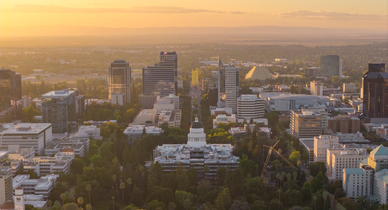 pexels-stephen-leonardi-587681991-34276138 Aerial view of Sacramento city skyline at sunset with the California State Capitol building in the foreground.