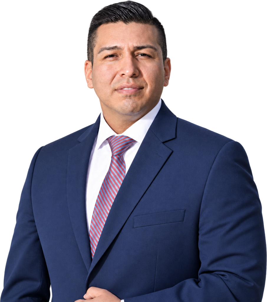 Man in a blue suit and striped tie, standing against a plain white background, looking at the camera.