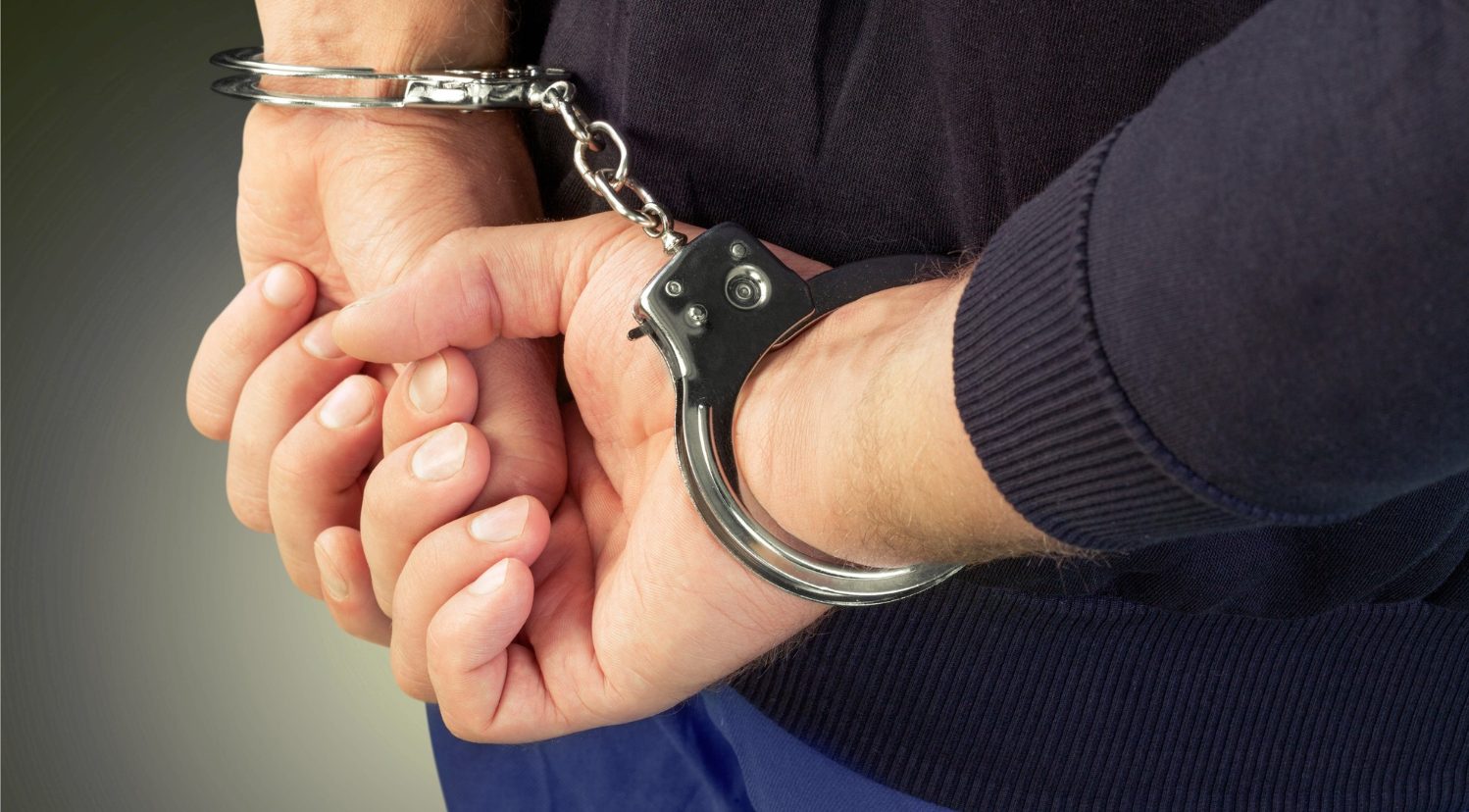 7262 Person’s hands handcuffed behind their back.